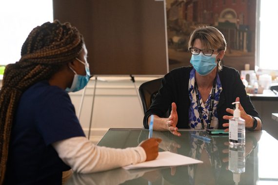 School of Nursing alumnus Rashida Charles (left) and School of Nursing assistant professor and researcher Marik Moen work at the Lord Baltimore Triage, Respite, and Isolation (TRI) Center, which treats people infected with COVID-19 who have no safe place to isolate.