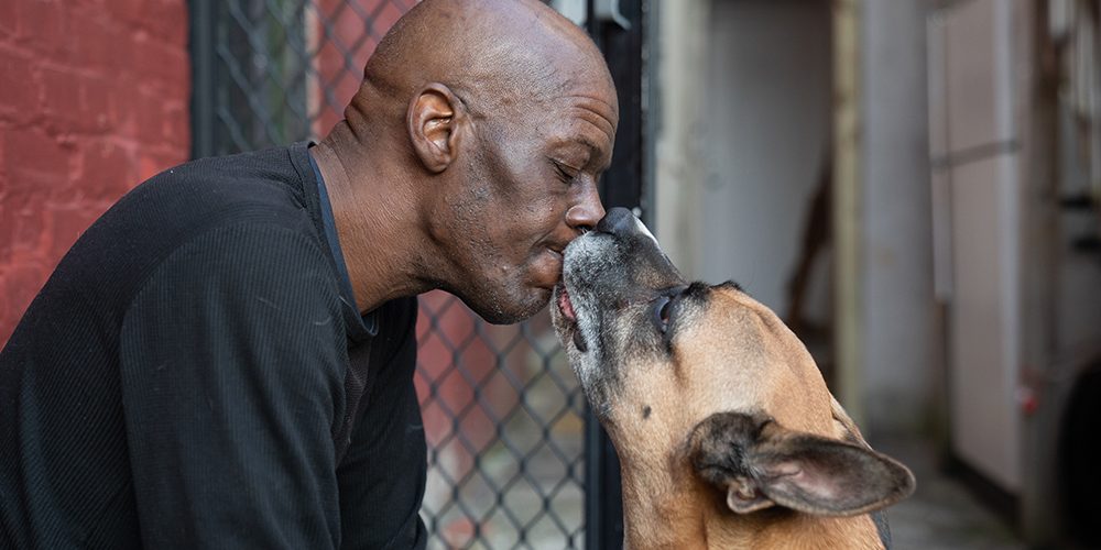 Maurice Joyner and his dog, King, who he has trained in German. That way, King won't listen to strangers' commands. He once lost a dog to someone who called his dog over, and then stole him.