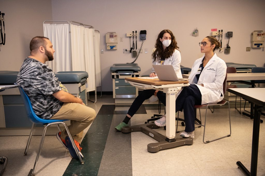 Kade Randall (left), a Standardized Patient, works with University of Maryland School of Nursing Doctor of Nursing Practice students Angela Gale (center) and Cierra Arias to help them better understand how to provide gender-affirming care. Photo by Matthew D’Agostino 