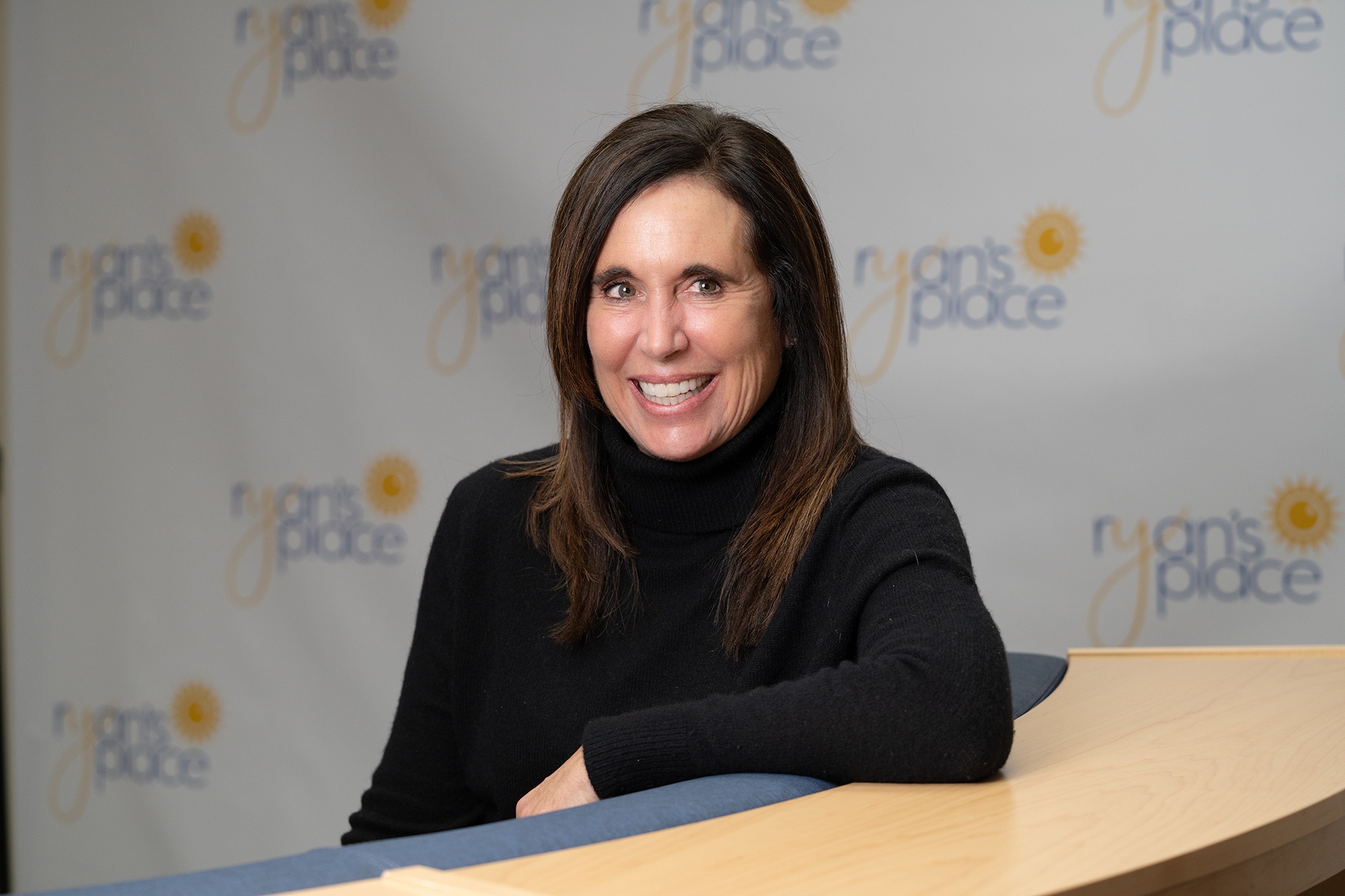 Debbie Sahlin, sitting at a desk at Ryan's Place.